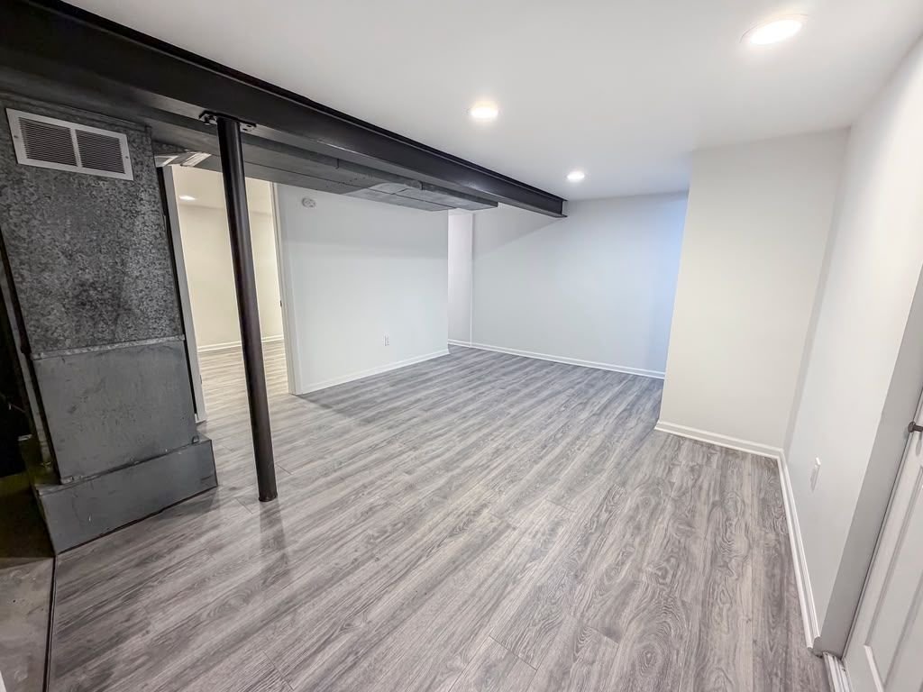 Finished basement with new flooring and recessed lighting