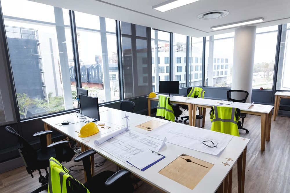 Oficina con planos y equipo de seguridad (foto de stock)